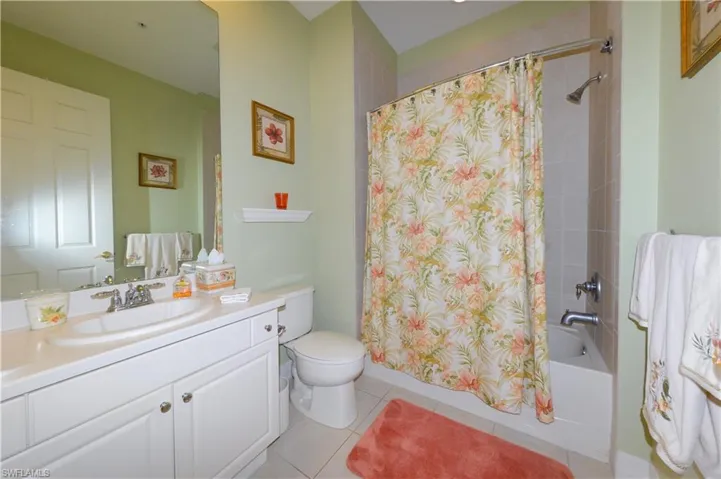 Guest bathroom features full tub and shower with upgraded tile walls in shower and shampoo niche & tile floors.