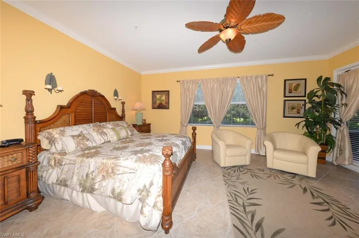 Large Primary Suite features, 20" tile flooring, Crown molding, large windows with views of the natural creek and preserve, a sitting area, door to the large Lanai, 2 walk-in closets and a beautiful en-suite bathroom.