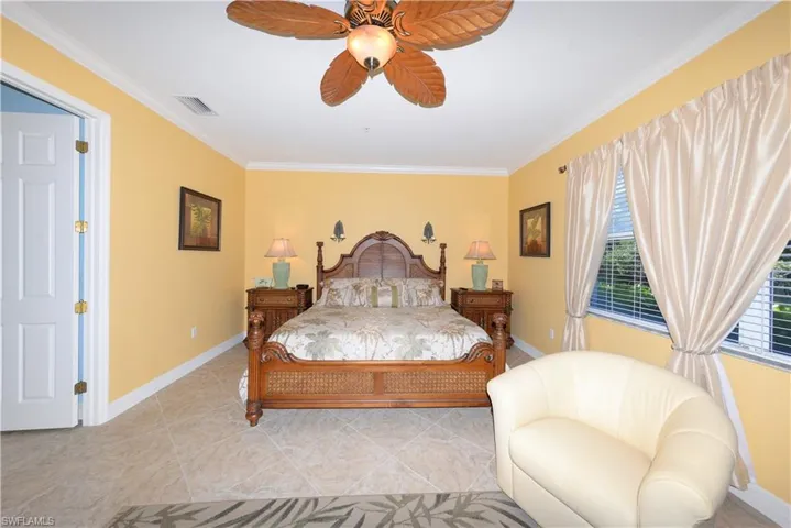 Large Primary Suite features, 20" tile flooring, Crown molding, large windows with views of the natural creek and preserve, a sitting area, door to the large Lanai, 2 walk-in closets and a beautiful en-suite bathroom.