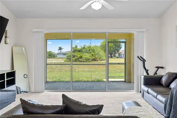 Unfurnished bedroom featuring light carpet, ensuite bath, and a ceiling fan