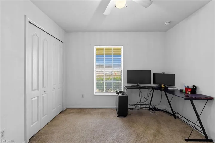 Unfurnished living room featuring light carpet, vaulted ceiling, a chandelier, and a ceiling fan