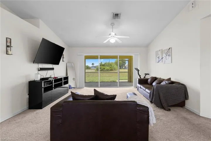 Carpeted spare room featuring ceiling fan and baseboards