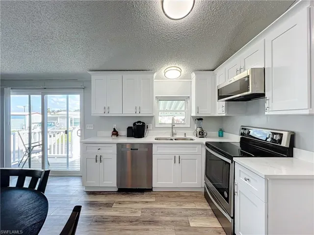 Kitchen featuring appliances, with white cabinets