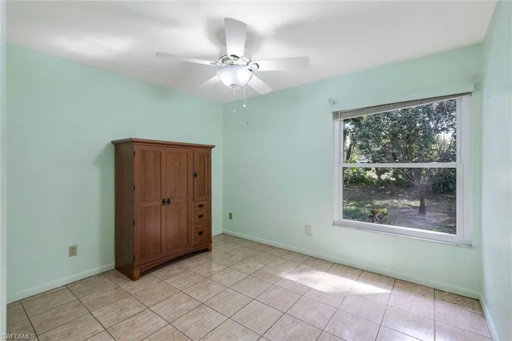 Unfurnished bedroom with ceiling fan and light tile patterned flooring