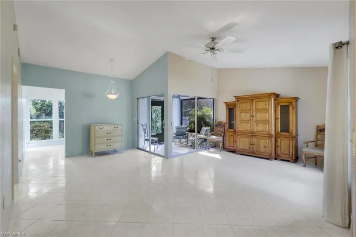 Tiled empty room with high vaulted ceiling and ceiling fan