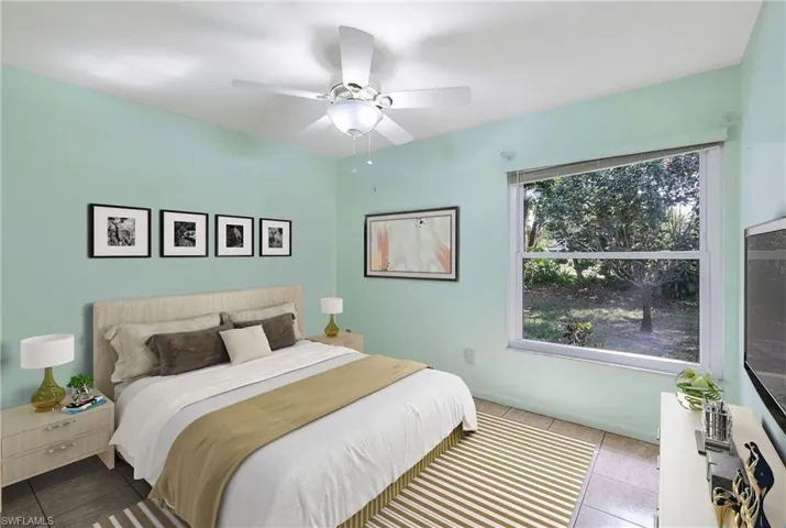 Staged Bedroom with ceiling fan and light tile patterned floors