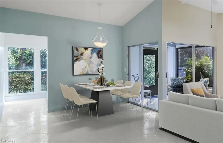 Staged dining room featuring high vaulted ceiling and a healthy amount of sunlight