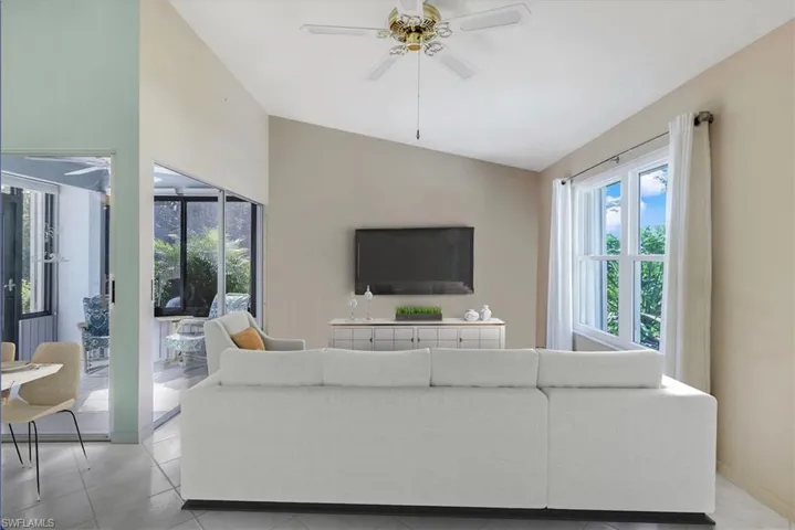 Staged living room with vaulted ceiling and ceiling fan