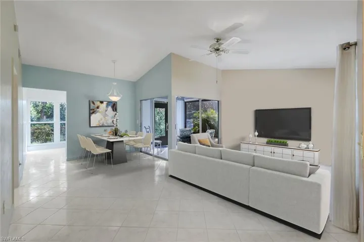 Staged Living room featuring ceiling fan, lofted ceiling, and light tile patterned flooring