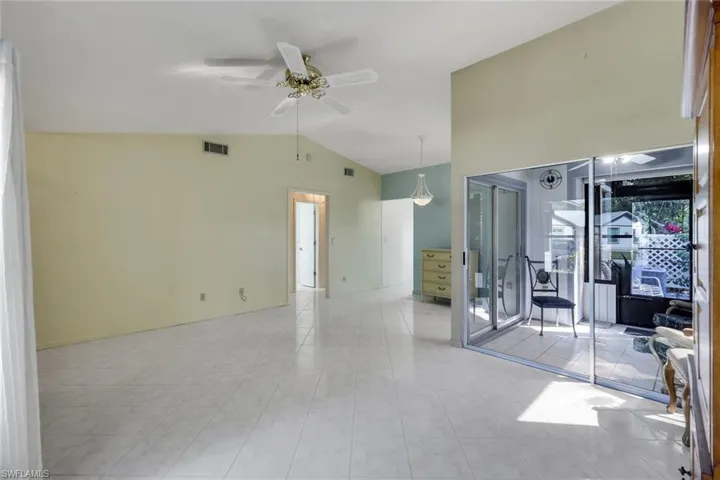 Empty room featuring ceiling fan and lofted ceiling