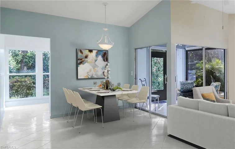 Staged dining room featuring high vaulted ceiling and a healthy amount of sunlight