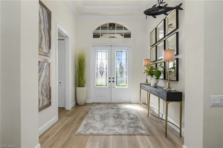 Foyer, luxury vinyl plank flooring, custom leaded glass double doors and tray ceiling.