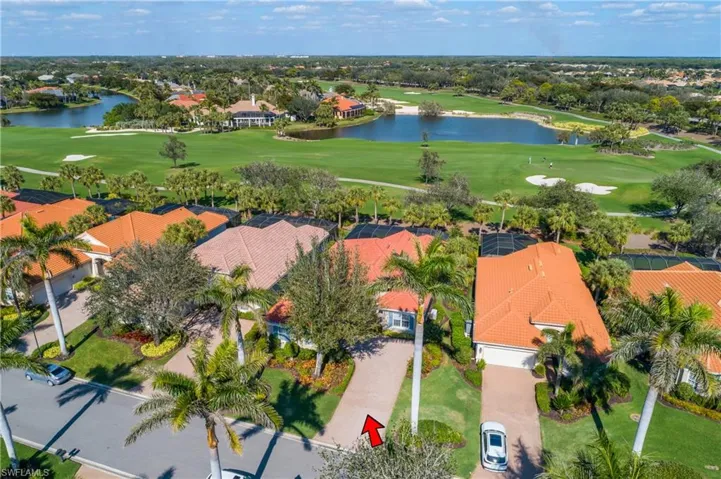 Driveway entry to house, lake beyond fairway #6. Majestic Royal Palms line the entire Ginger Pointe Ct roadway.