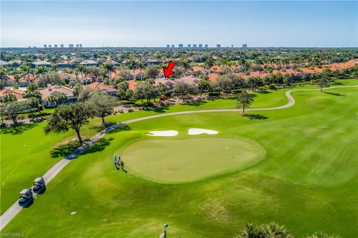 Looking southwest towards house from drone shot over #6 green...golfers and carts at a significant distance from lanai. Condo high rise buildings are on the Gulf of America beaches.