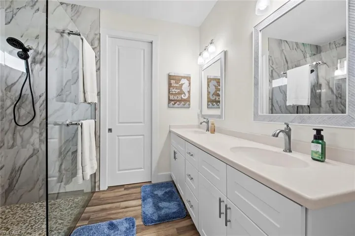 Master Bathroom featuring a tile shower, vanity, and hardwood / wood-style flooring