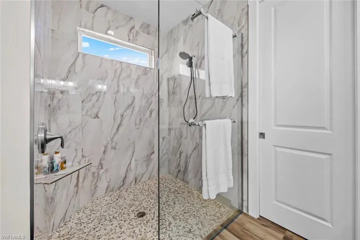 Master Bathroom with hardwood / wood-style floors and tiled shower