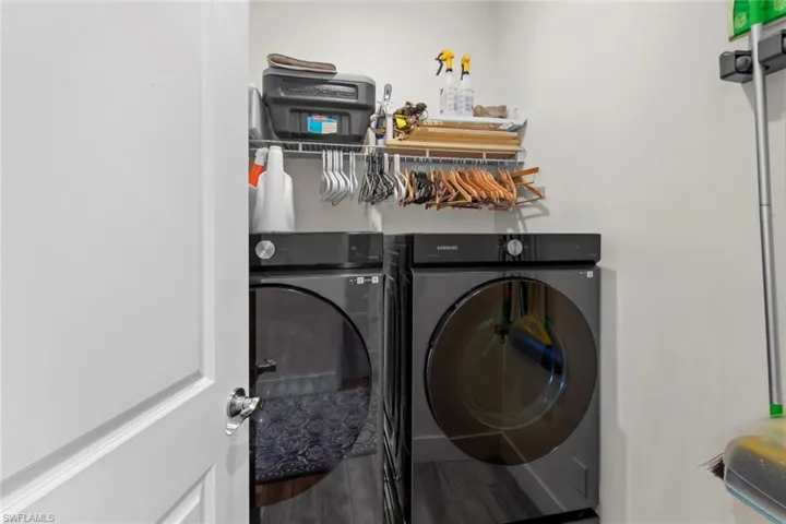 Laundry room featuring hardwood / wood-style floors and washing machine and clothes dryer