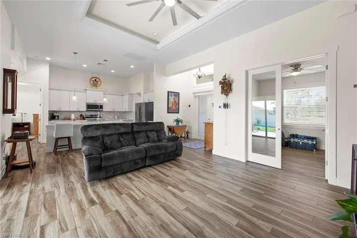 Living room featuring a tray ceiling, light hardwood / wood-style floors, and ceiling fan
