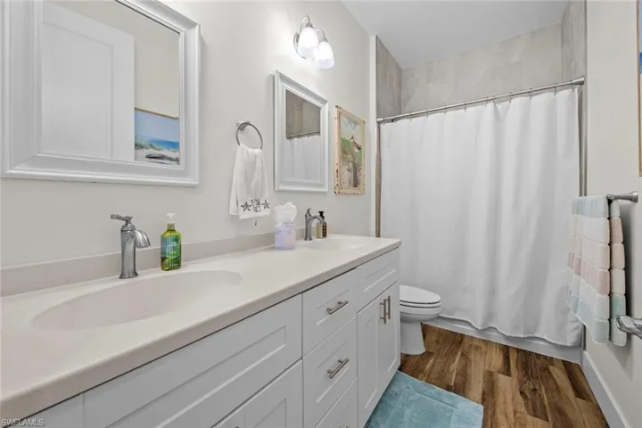 Guest Bathroom featuring hardwood / wood-style floors, vanity, and toilet