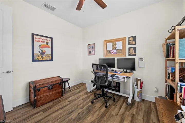 Bedroom #3 featured as an office with ceiling fan and hardwood / wood-style flooring
