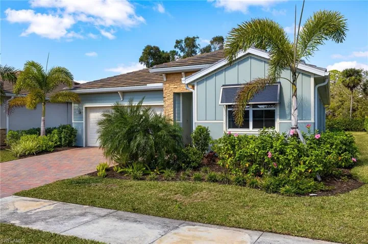 View of front of property featuring a garage and a front lawn