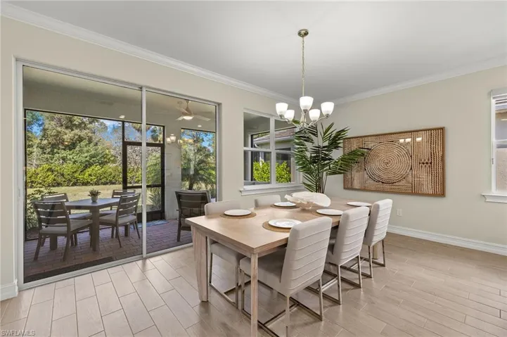Dining area with ornamental molding and a chandelier