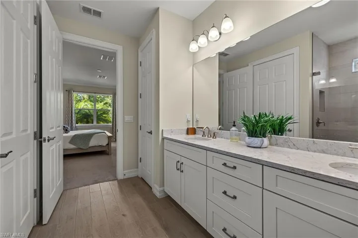 Bathroom with vanity, hardwood / wood-style flooring, and walk in shower