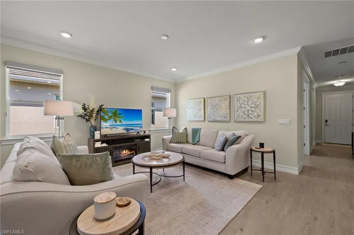 Living room featuring ornamental molding and light hardwood / wood-style floors