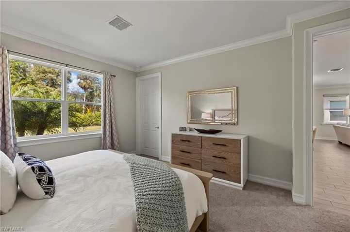 Carpeted bedroom featuring crown molding