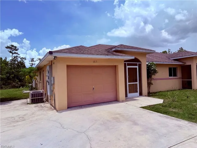 Ranch-style house with stucco siding, driveway, a shingled roof, and an attached garage