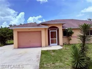 View of front of home with driveway, a front yard, an attached garage, and stucco siding