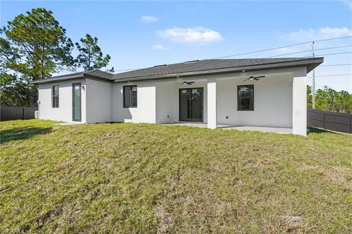Back of structure showing patio and fenced yard