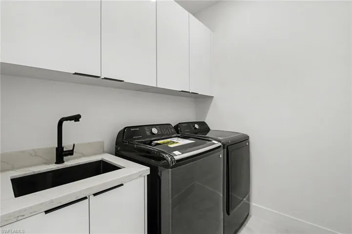 Laundry room with washer, dryer, and cabinet storage