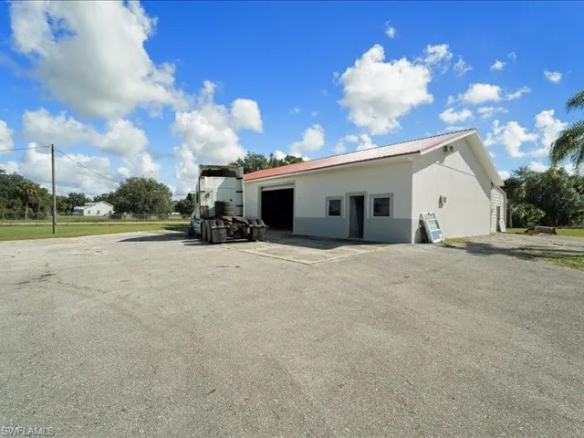 Back of house featuring a garage and an outdoor structure