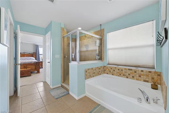 Primary bathroom featuring a garden tub, a shower stall, and tile patterned floors