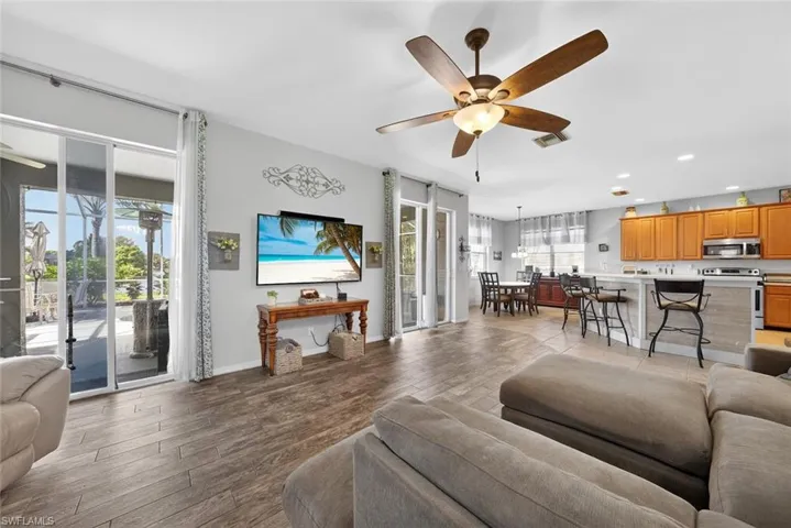 Family room featuring a ceiling fan, tile floors, and a view of the lanai