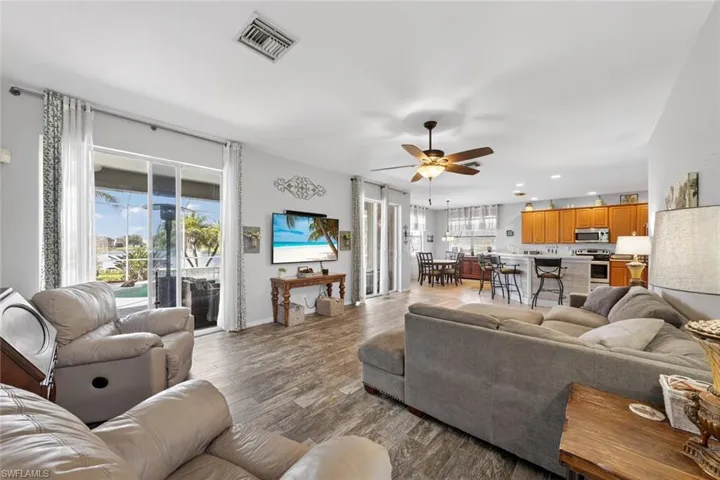 Family room with a ceiling fan, double sliders, and tile floors