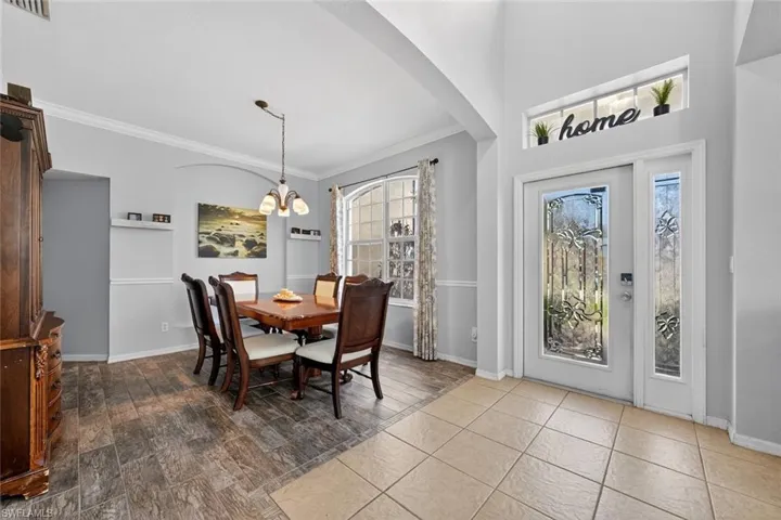 Formal dining space with crown molding, a chandelier, and tile finished floors