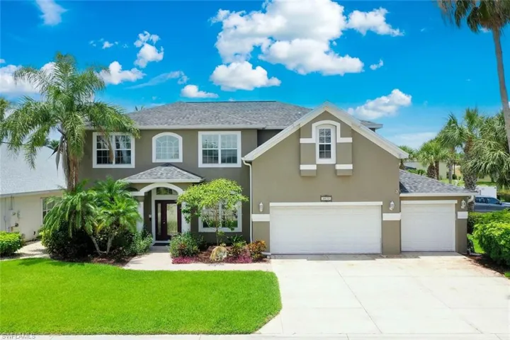 View of front of property featuring stucco siding, a front yard, driveway, and an attached garage