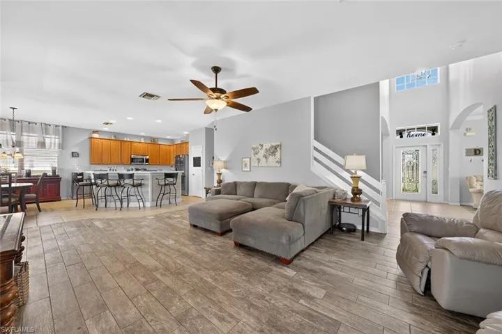 Family room with a ceiling fan, tile floors, and stairway