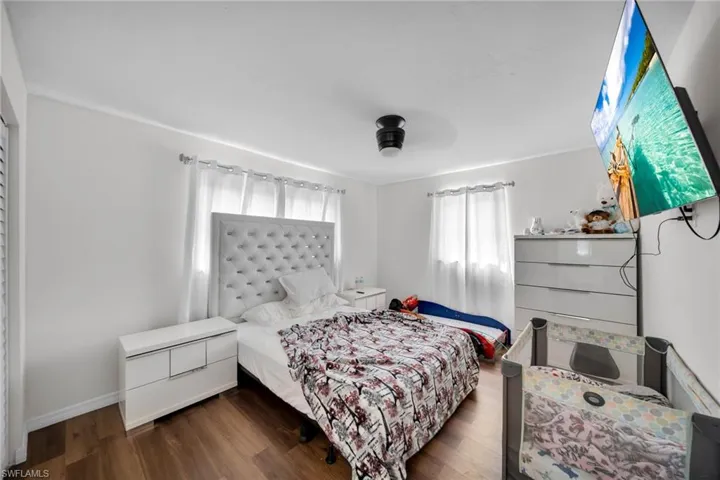 Bedroom with wood finished floors and baseboards