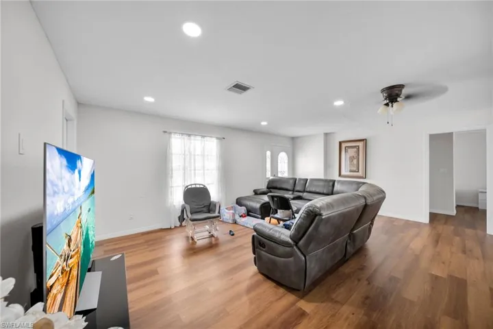 Living room with wood finished floors, recessed lighting, baseboards, and ceiling fan