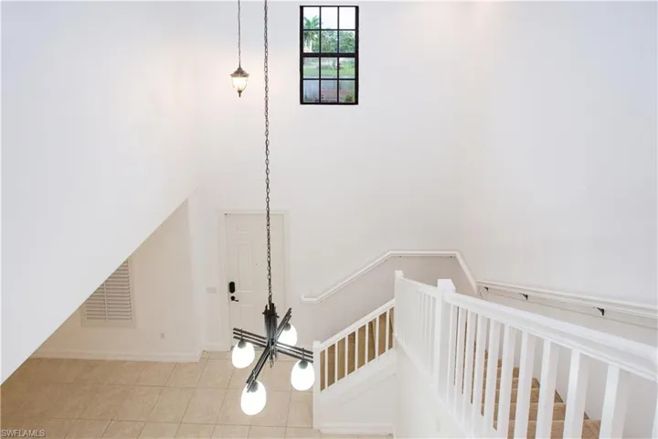 Stairway featuring light tile floors
