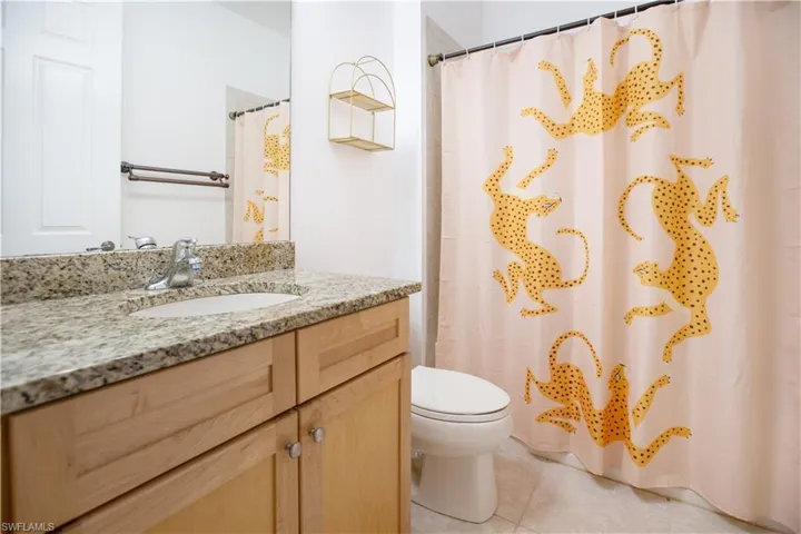 Bathroom featuring tile flooring, oversized vanity, and toilet