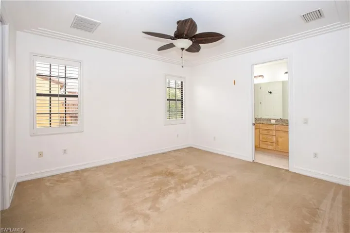 Unfurnished room featuring crown molding, plantation shutters, and ceiling fan