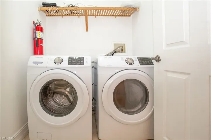 Laundry room with tile floors, hookup for a washing machine, and washer and clothes dryer
