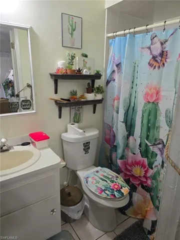 Full bathroom with tile patterned flooring, vanity, and a shower with shower curtain