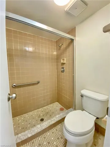 Full bath with a stall shower and tile patterned flooring