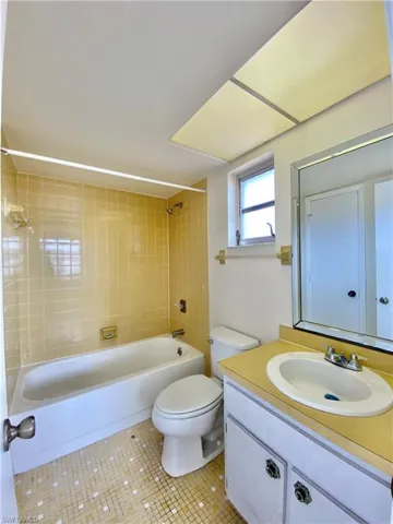 Full bath featuring vanity, washtub / shower combination, and tile patterned floors
