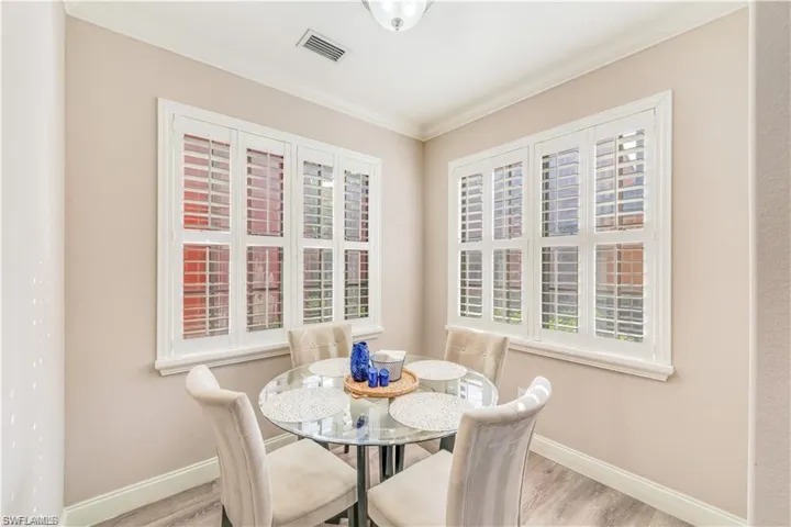 Dining area with light wood-type flooring and crown molding